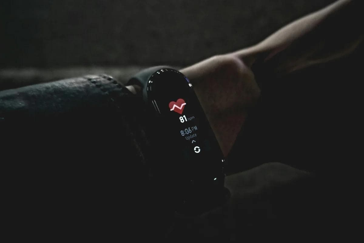 Close-up of a smartwatch in the dark, displaying a heart rate of 81 bpm at 8:06 PM.